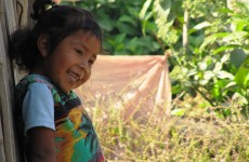 Silvia stands against a dilapidated sugarcane hut that is her “house”...