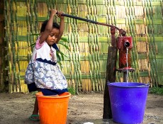 Travel the World – A child pumps water into a dirty...