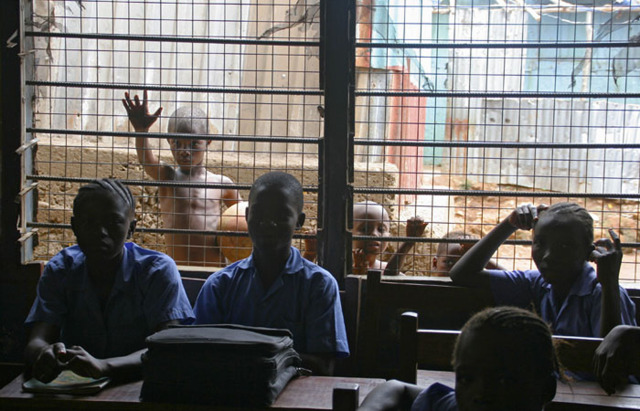Children look in to a classroom in a Freetown slum. 